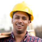 A construction worker smiling with a hard hat, showcasing lower labor costs.
